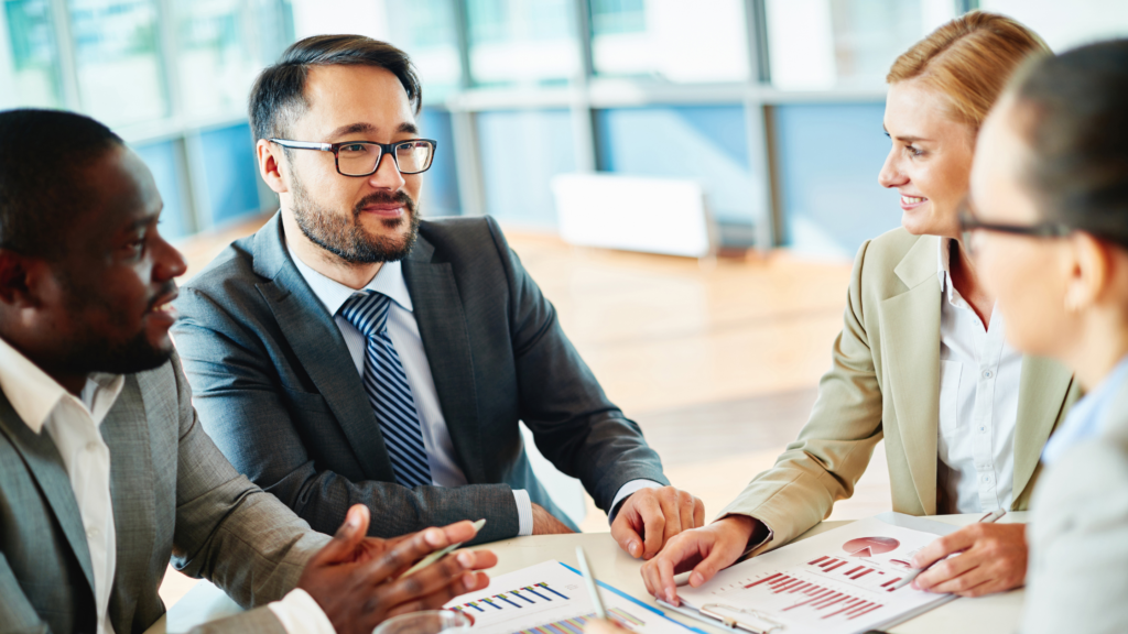 IT consultants are meeting with their clients, going over data and graphs.