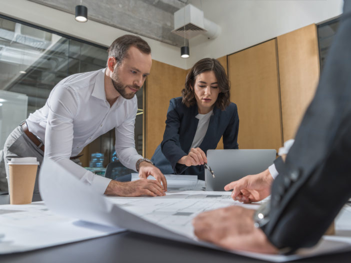 Professionals looking at and discussing paperwork on a table